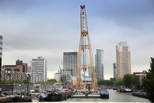 ROTTERDAM, THE NETHERLANDS - 18 AUGUST: Old cranes in Historical Leuvehaven, Rotterdam's oldest sea port. Harbor and modern apartment buildings in Rotterdam, Netherlands on August 18,2015.