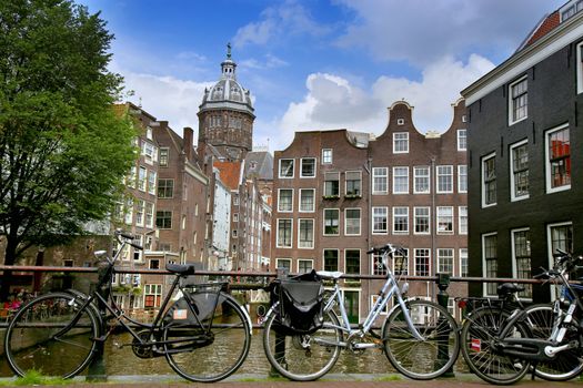 AMSTERDAM, THE NETHERLANDS - AUGUST 19, 2015: View on Saint Nicholas church or St Nicolaas kerk tower from Armbrug bridge. Street life, Canal, tourists and boat in Amsterdam. Amsterdam is capital of the Netherlands on August 19, 2015.