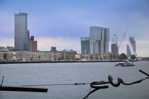 ROTTERDAM, THE NETHERLANDS - 18 AUGUST: Rotterdam is a city modern architecture, view on Erasmus Bridge (Erasmusbrug) and skyline of Rotterdam with a cruise boat, river Maas in Rotterdam, Netherlands on August 18,2015.