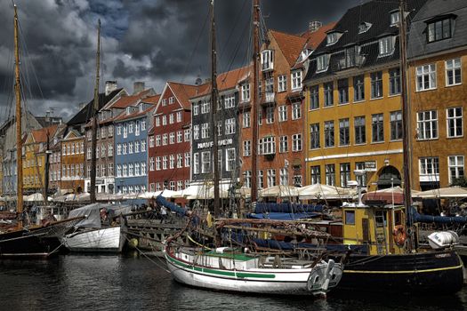 COPENHAGEN, DENMARK - AUGUST 14, 2016: Boats in the docks Nyhavn, people, restaurants and colorful architecture. Nyhavn a 17th century harbour in Copenhagen, Denmark on August 14, 2016.