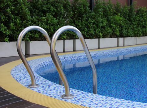 Grab bars ladder in blue swimming pool