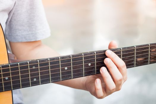 Woman's hands playing acoustic guitar, stock photo