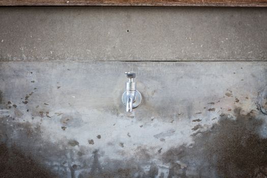 Water tap on grey background, stock photo