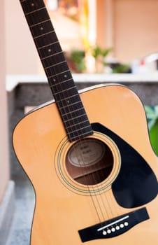 Acoustic guitar on orange wall background, stock photo