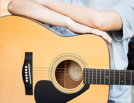 Woman's hands with acoustic guitar in relax post, stock photo