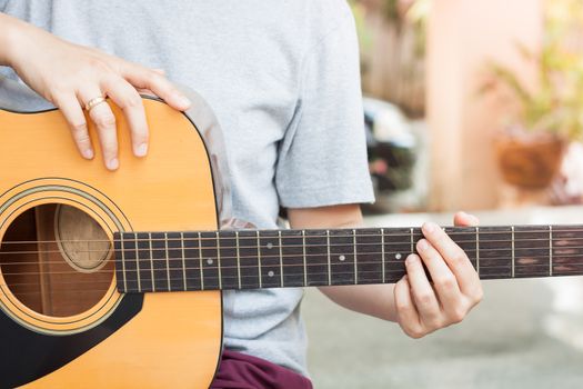 Woman's hands playing acoustic guitar, stock photo