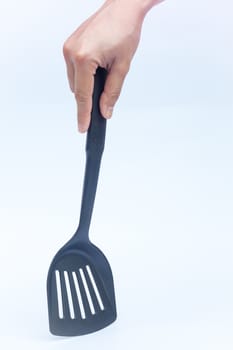 Black plastic kitchen spatula on white background, stock photo