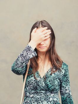 facepalm girl. Portrait of young woman doing facepalm posing against gray wall background. Vertical