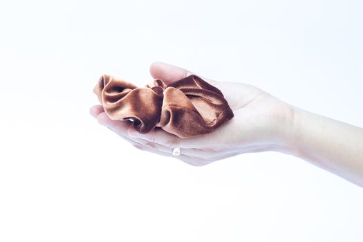 Woman hand holding hair rubber band on white background