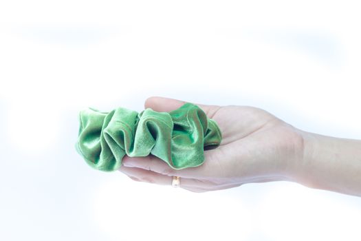 Woman hand holding hair rubber band on white background