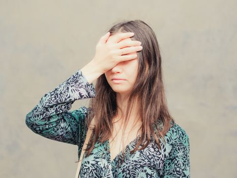 facepalm girl. Portrait of young woman doing facepalm posing against gray wall background