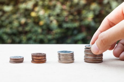 Woman hand putting money coin for saving money concept