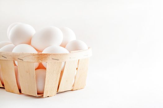 full basket of fresh eggs on a white background/