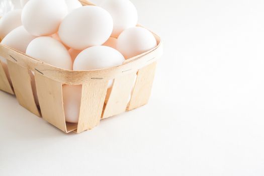 full basket of fresh eggs on a white background/