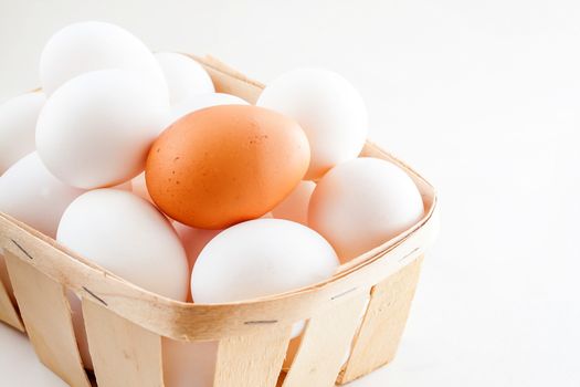 full basket of fresh eggs on a white background/