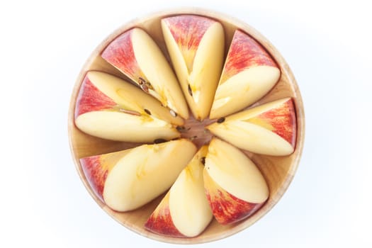 Sliced apple in wooden bowl on white background