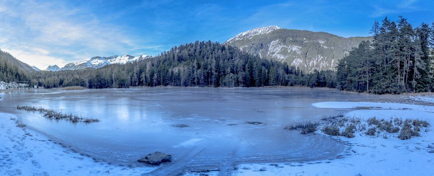 Winter landscape with a frozen lake and the Austrian Alps in background. Image taken near the village Biberwier, from the district Reutte, Austria.