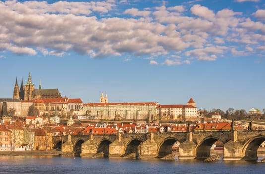 Cityscape in Prague, the capital of Czech Republic, with Charles Bridge under a blue sky with white clouds.