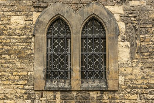 Architectural image with two windows from an old wall stoned church.