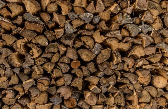 Close up image with a firewood pile prepared for winter.