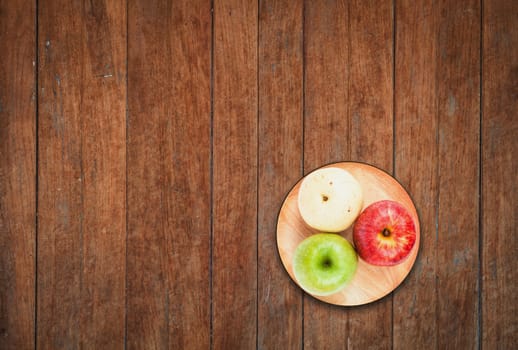 Top view of three different kind of apples on wooden background