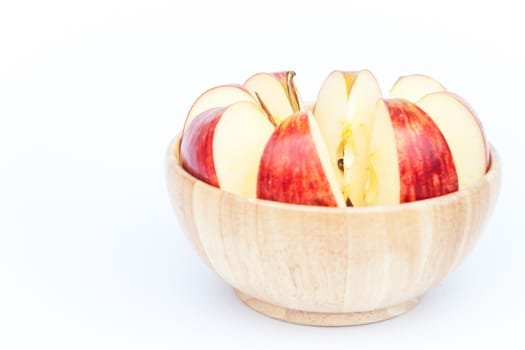 Sliced apple in wooden bowl on white background