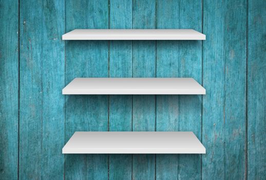 Three white shelves on blue wooden interior texture background, stock photo