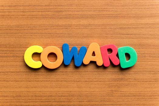 coward colorful word on the wooden background