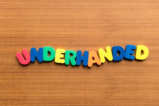 underhanded colorful word on the wooden background
