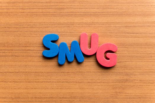 smug colorful word on the wooden background