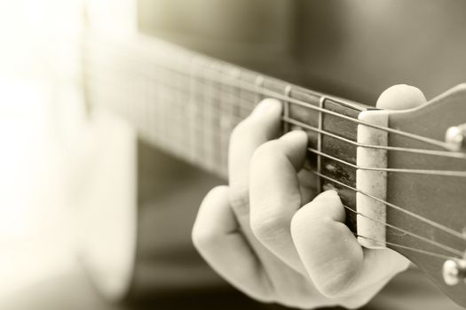 Woman's hands playing acoustic guitar with vintage filter, stock photo