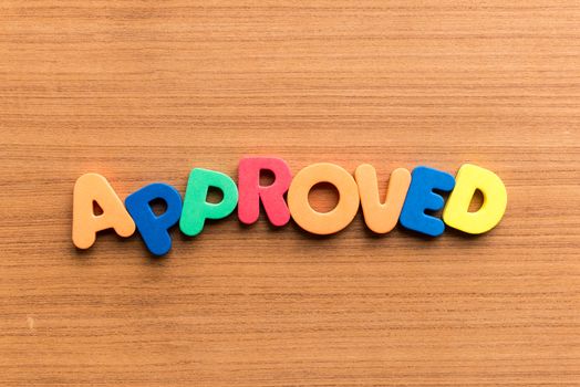 approved colorful word on the wooden background