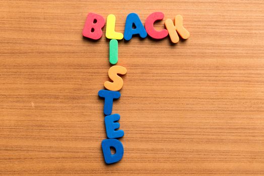 black listed colorful word on the wooden background