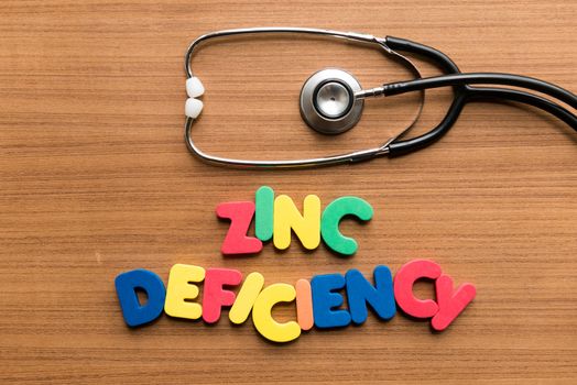zinc deficiency colorful word with stethoscope on wooden background