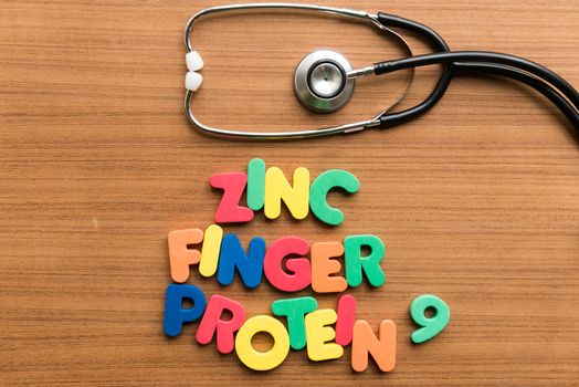 zinc finger protein 9 colorful word with stethoscope on wooden background