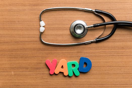 yard colorful word with stethoscope on wooden background