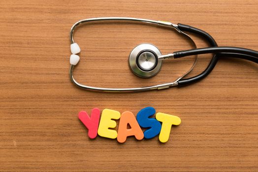 yeast colorful word with stethoscope on wooden background