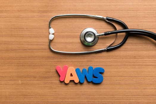 yaws colorful word with stethoscope on wooden background