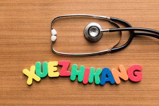 xuezhikang colorful word with stethoscope on wooden background