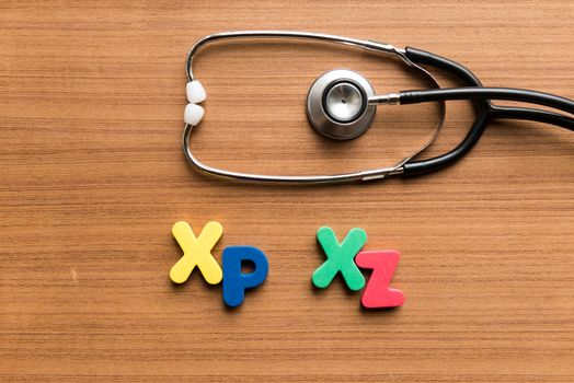 xp xz colorful word with stethoscope on wooden background