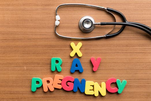x ray pregnency colorful word with stethoscope on wooden background