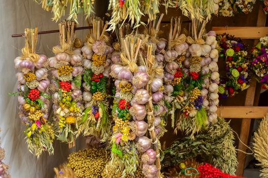 Decorative and fresh garlic bulbs hanging from market stall