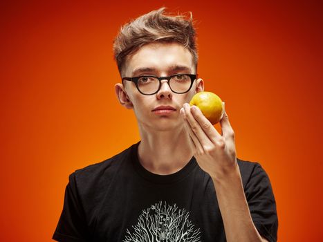 Emotional portrait of a teenager with lemona on a red background