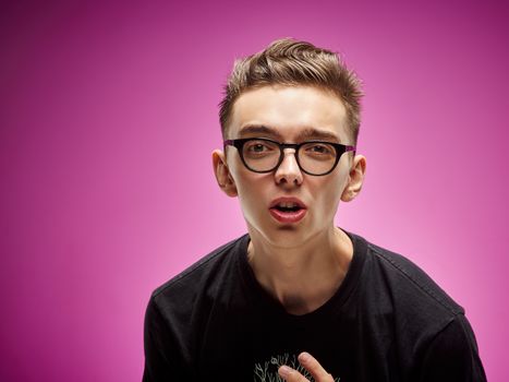 Emotional portrait of a teenager on a pink background