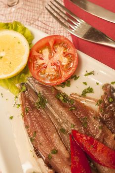 marinaded sprat with vegetables on white plate