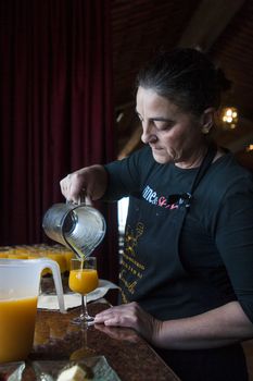 Tenerife, Spain, January 2015: Waitress pours fresh juice for customers on Bodega Monje- one of leading wine manufactures on north of Tenerife