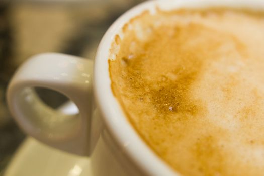 white ceramic cup with hot coffee  close up blurred