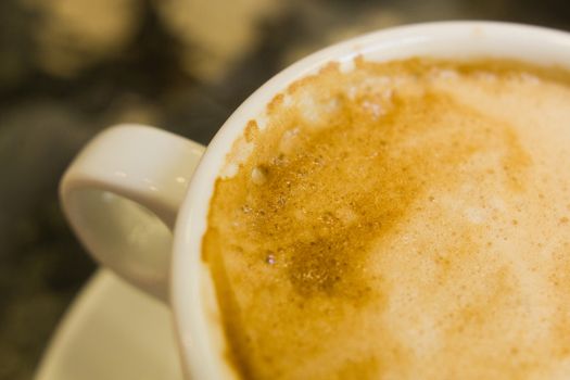 white ceramic cup with hot coffee  close up blurred