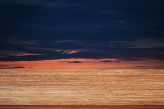 Wooden table top with sunrise on the lake with beautiful sky