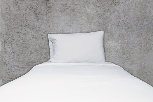 Close up white bedding and pillow on abstract gray concrete texture background